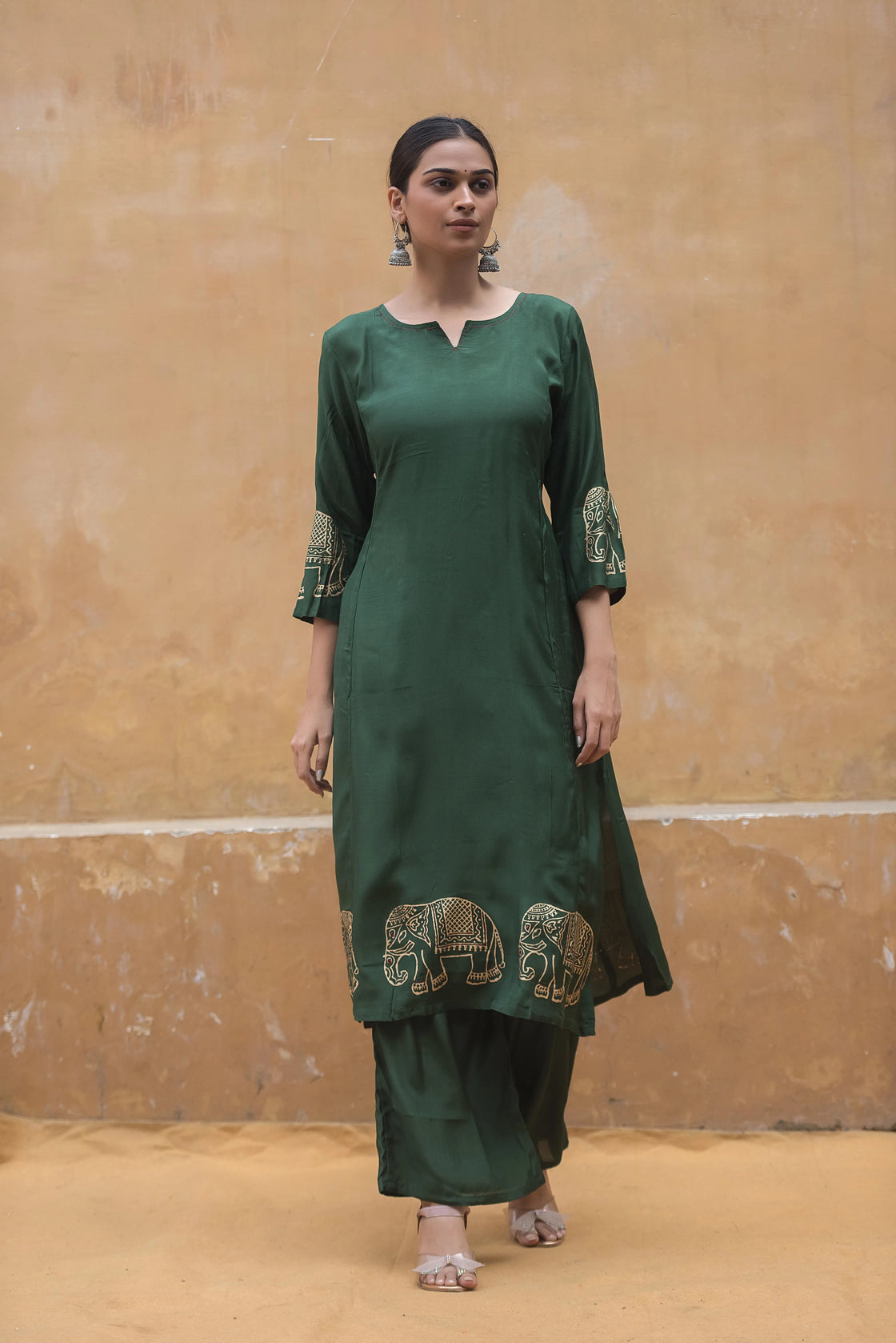 Woman relaxing in a comfortable bottle green muslin kurti pant set, perfect for casual occasions.