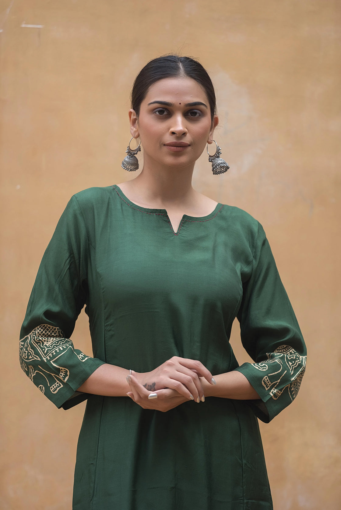 Close-up of bottle green muslin kurti with intricate katha work and block print detail.