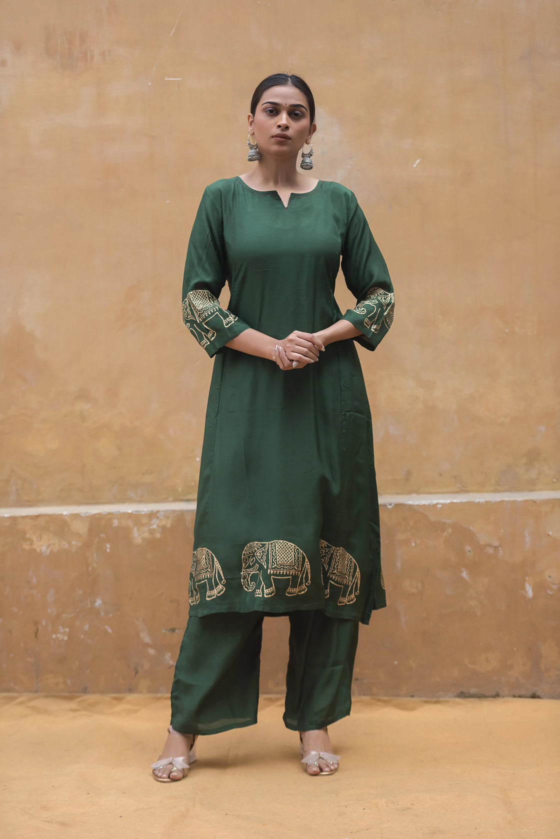 Woman wearing a bottle green muslin kurti pant set with katha work and block print.