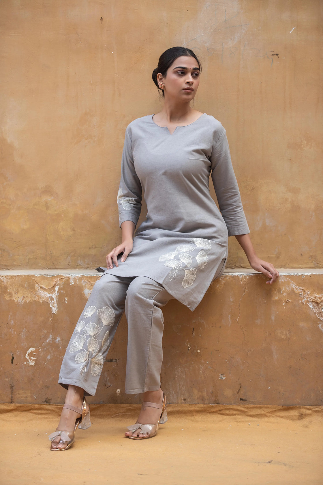 Woman traveling in a grey flex cotton co-ord set with floral embroidery, showcasing comfort and style.